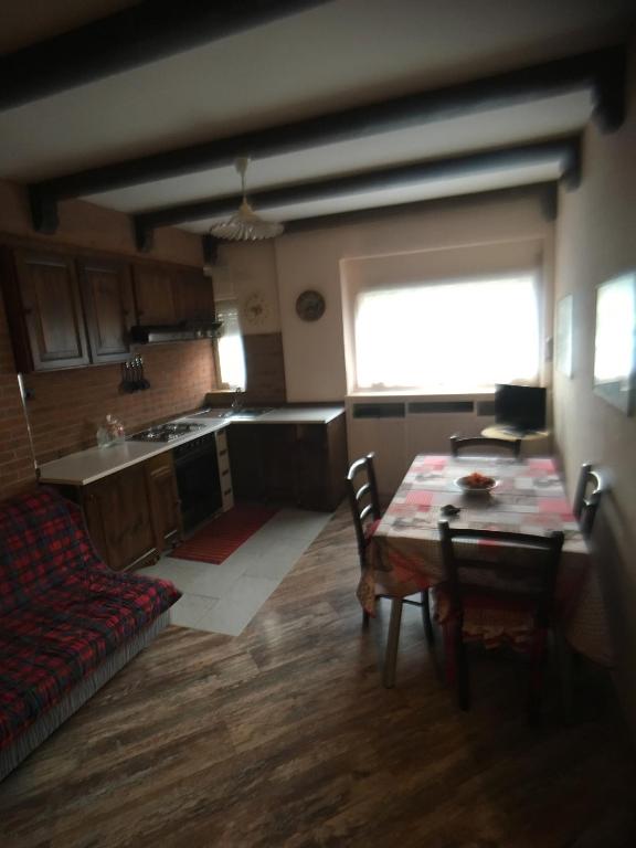 a kitchen with a table and chairs and a couch at Il Capriolo in Sauze dʼOulx