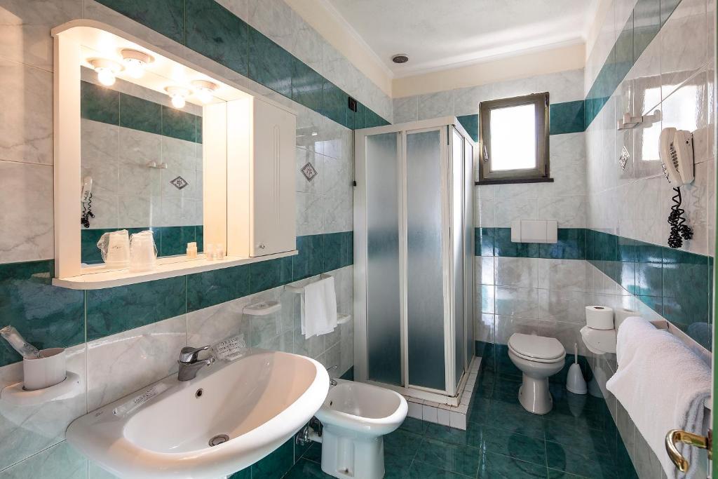 a bathroom with a sink and a toilet and a mirror at Sorriso Thermae Resort & Spa in Ischia