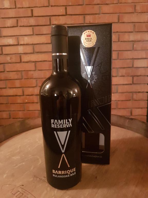 a bottle of wine sitting on a table next to a box at Pension Sunset Mezirolí in Nová Role