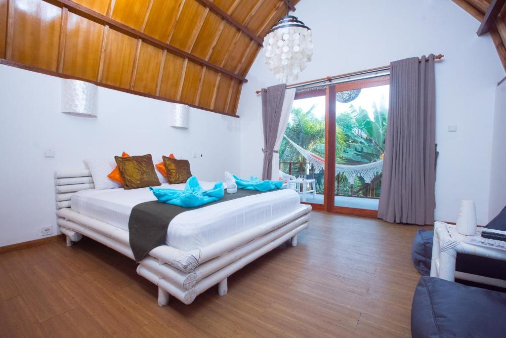 a bedroom with a large white bed with blue pillows at My Gili Paradise in Gili Trawangan