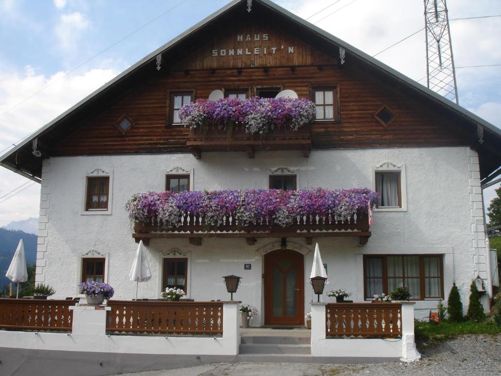 een huis met paarse bloemen op het balkon bij Haus Sonnleitn in Sankt Johann im Pongau