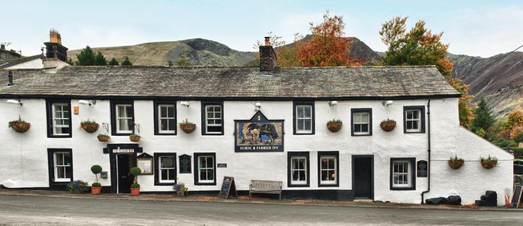 a white building sitting on the side of a street at The Horse and Farrier Inn and The Salutation Inn Threlkeld Keswick in Threlkeld