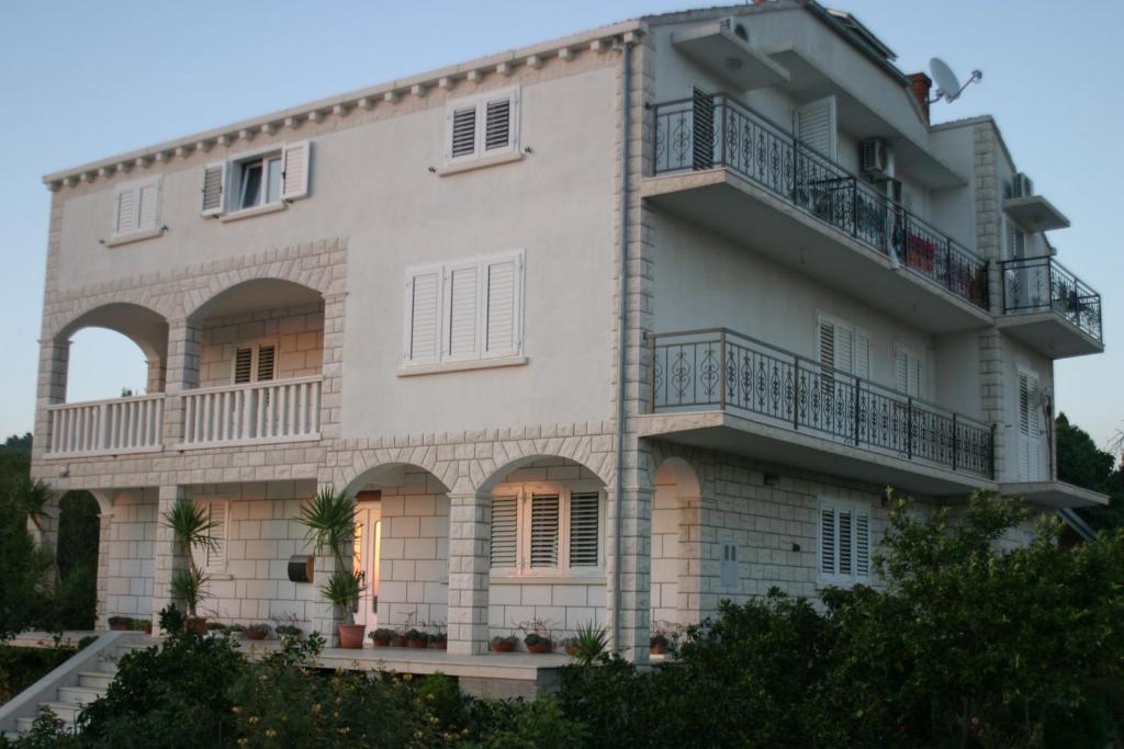 a large white building with balconies at Apartments Vela Luka in Vela Luka