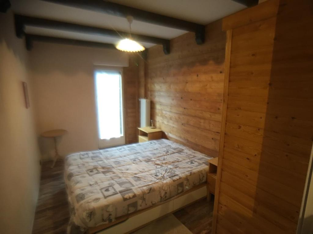 una camera con un letto su una parete in legno di Il Capriolo a Sauze d'Oulx