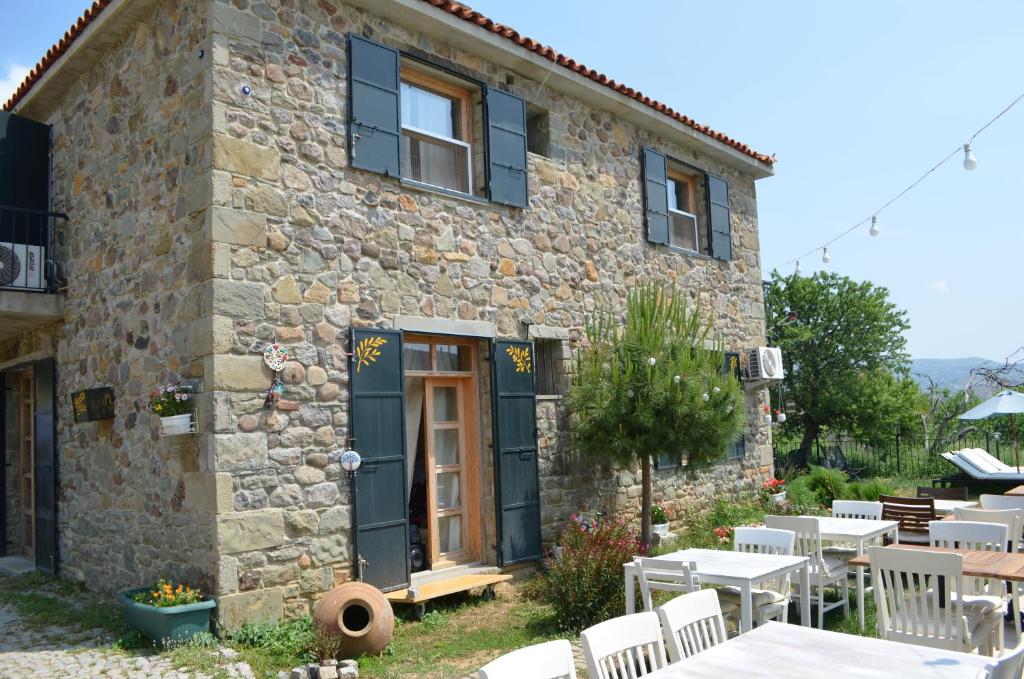 a stone house with tables and chairs in front of it at Son Vapur Butik Otel in Gokceada Town