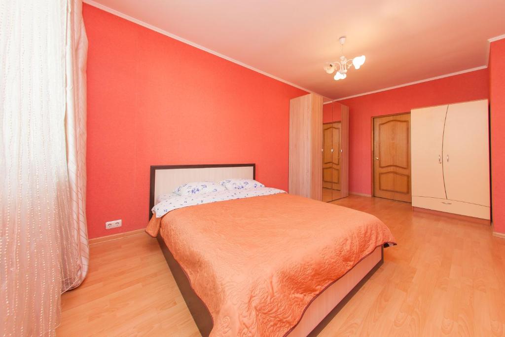 モスクワにあるApartment Coralの赤い壁のベッドルーム1室(ベッド1台付)