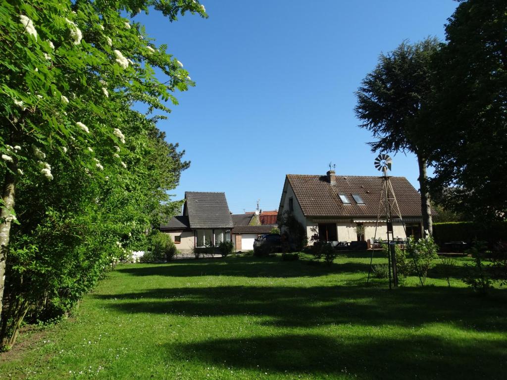 a house with a yard with green grass and trees at La Grange du Verger in Villers-Bretonneux