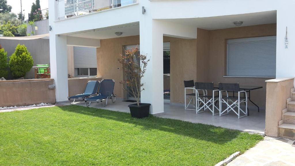 d'une terrasse avec des chaises, une table et de la pelouse. dans l'établissement My Home, à Kavala