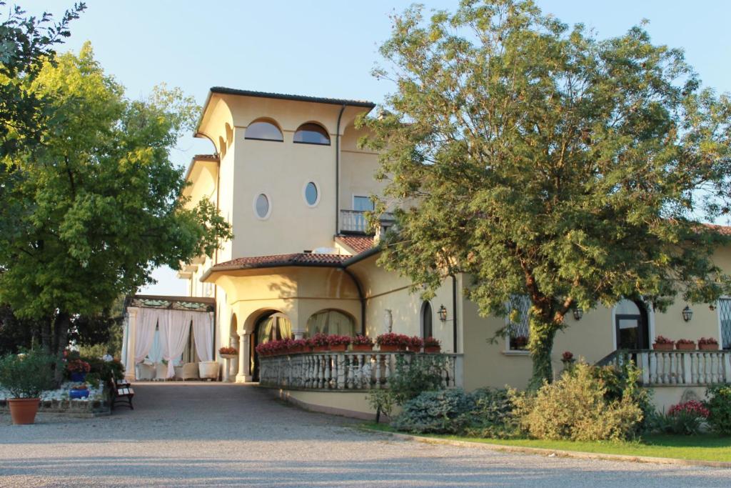 ein großes gelbes Haus mit Auffahrt in der Unterkunft Villa Belvedere 1849 in Misano di Gera dʼAdda