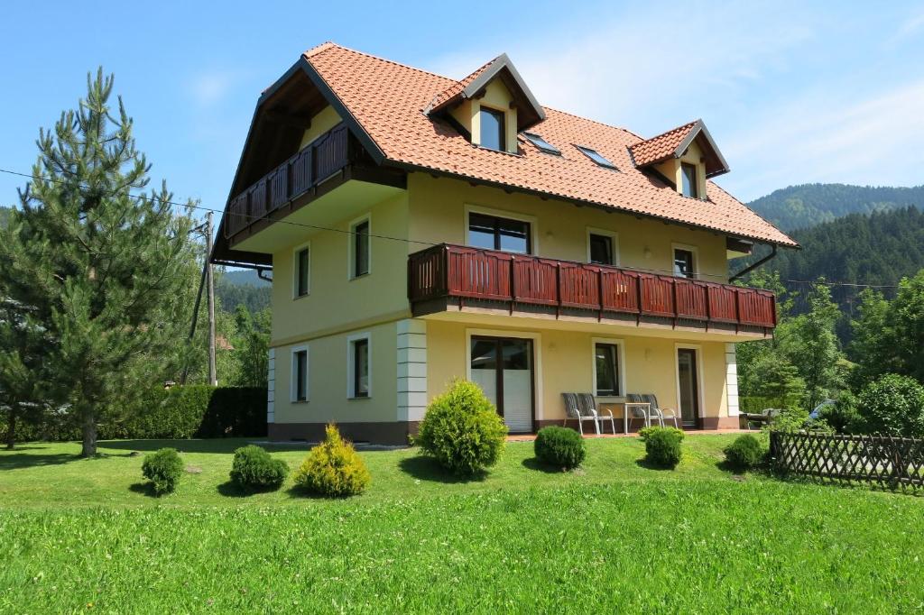 een groot geel huis met een rood dak bij Villa Planina in Kranjska Gora