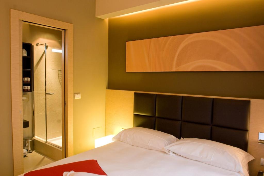 A bed or beds in a room at UNAHOTELS Villa dei Platani Foligno