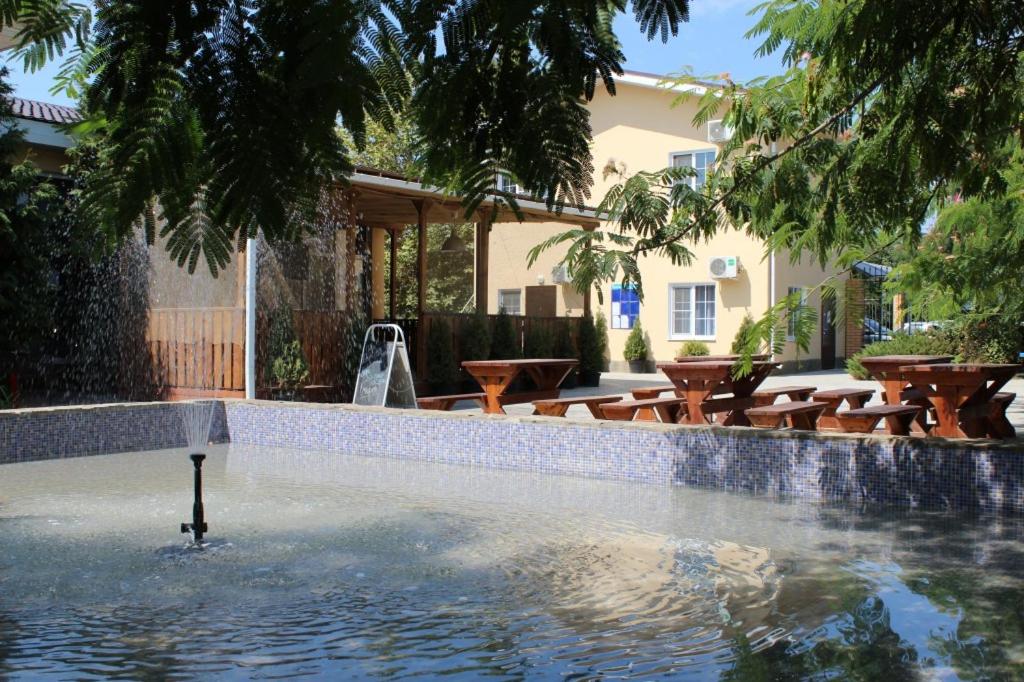 a swimming pool with tables and chairs in a house at Guest House Golubaya Buhta in Kuchugury