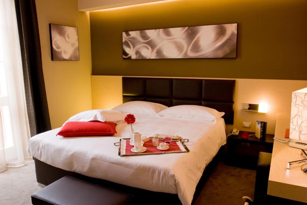 A bed or beds in a room at UNAHOTELS Villa dei Platani Foligno