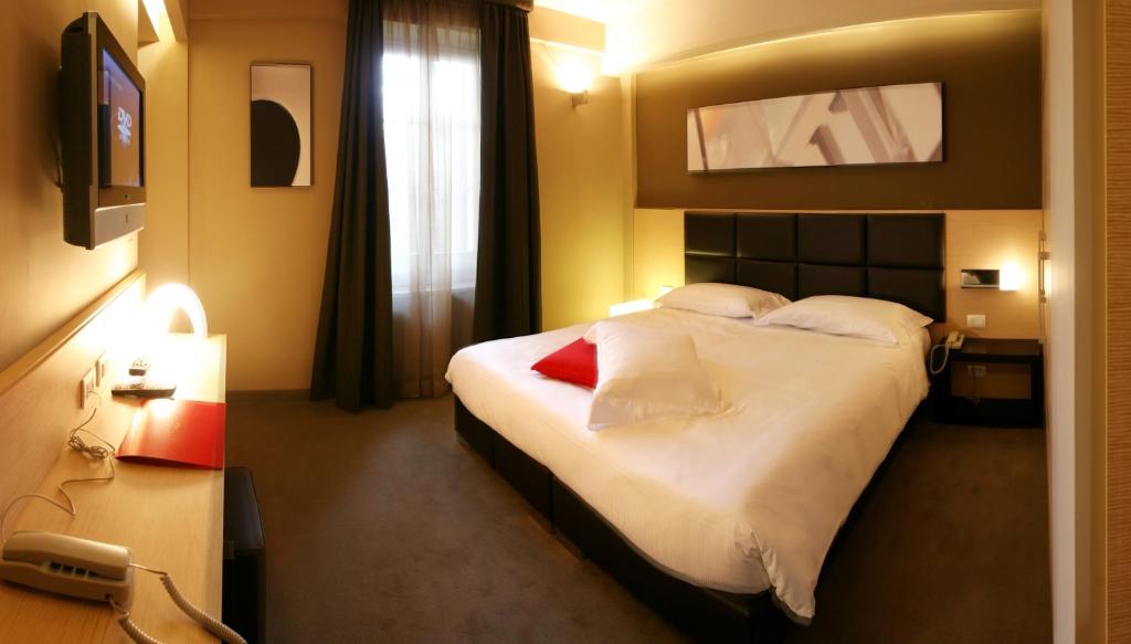A bed or beds in a room at UNAHOTELS Villa dei Platani Foligno