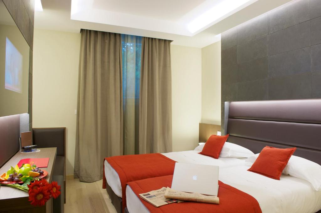 A bed or beds in a room at UNAHOTELS Villa dei Platani Foligno