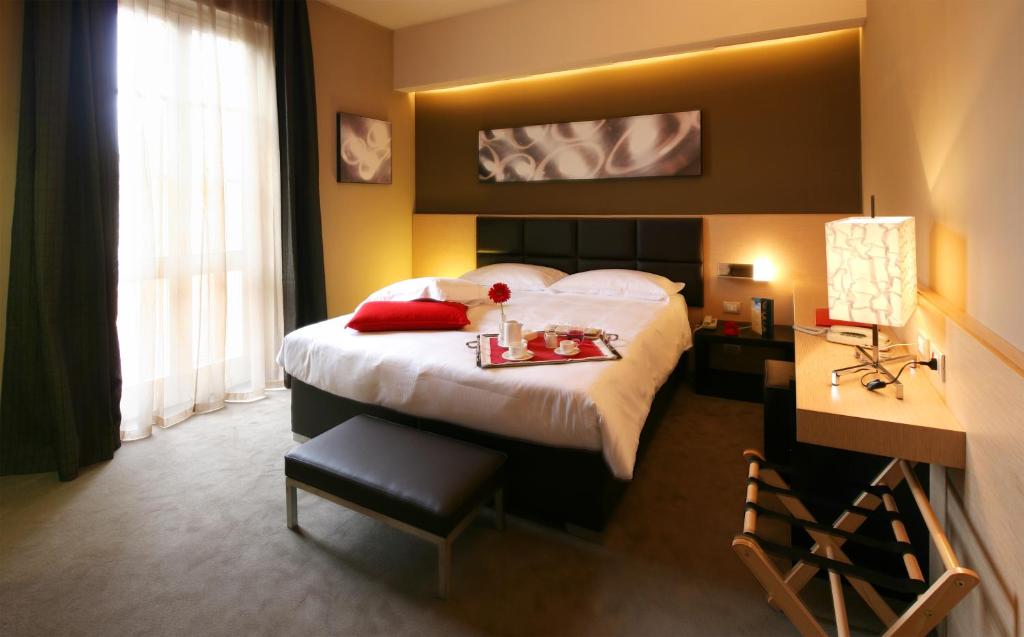 A bed or beds in a room at UNAHOTELS Villa dei Platani Foligno
