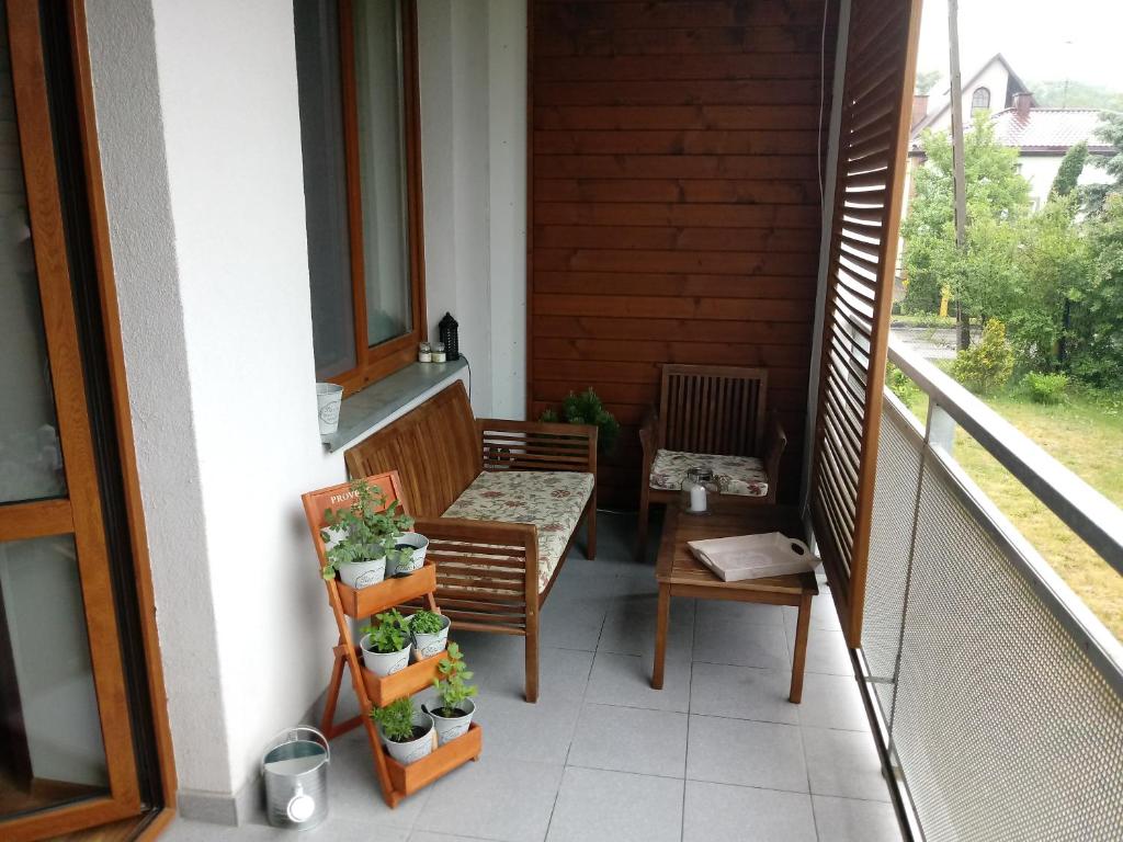 a balcony with a bench and some plants on it at apartament Fanaberia in Zwierzyniec