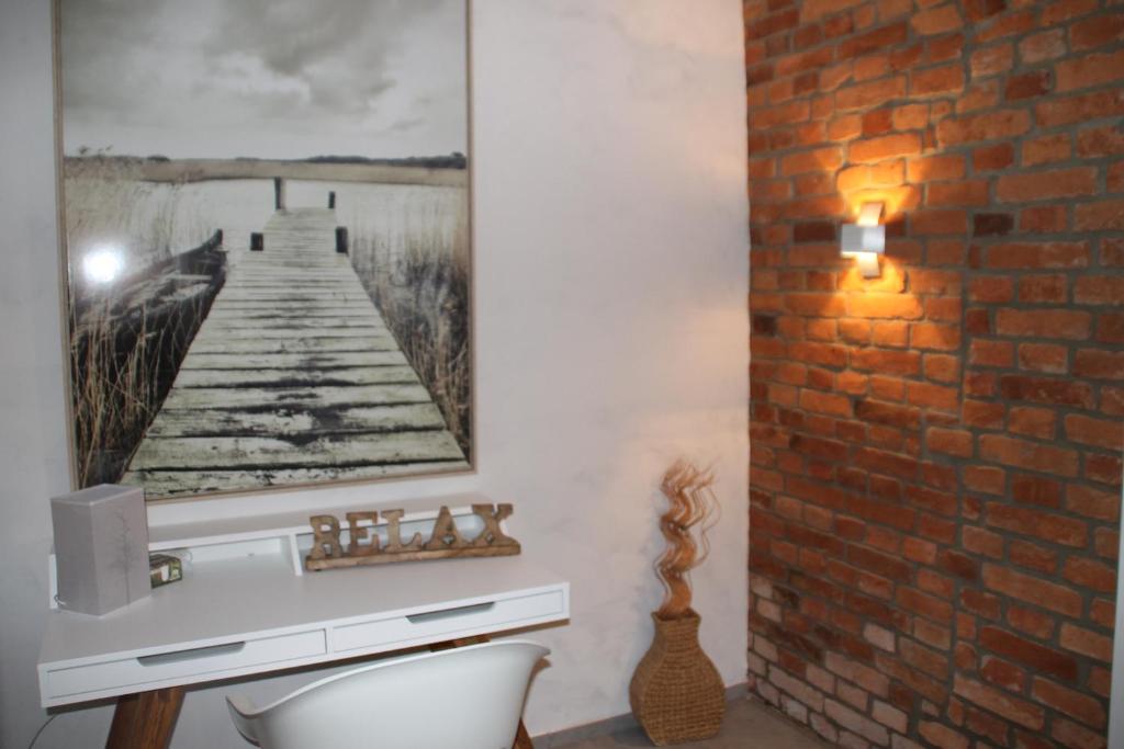 a bathroom with a brick wall with a picture of a pier at Ruhezone in Bremke