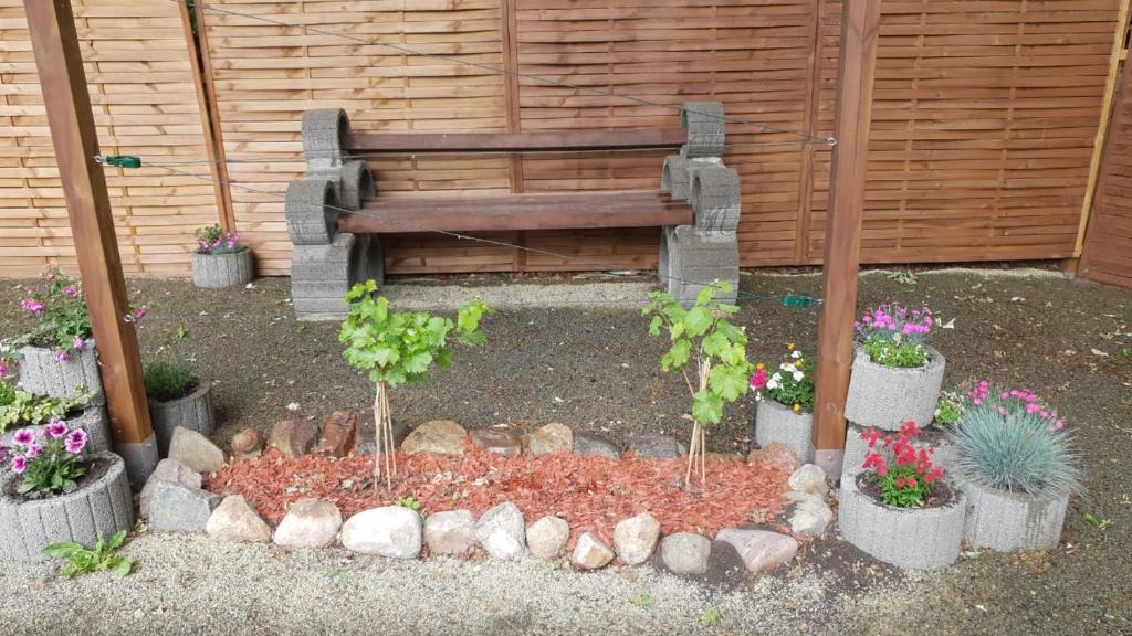 a garden with a bench and potted plants at Landhotel Sonnenschein in Bad Liebenwerda