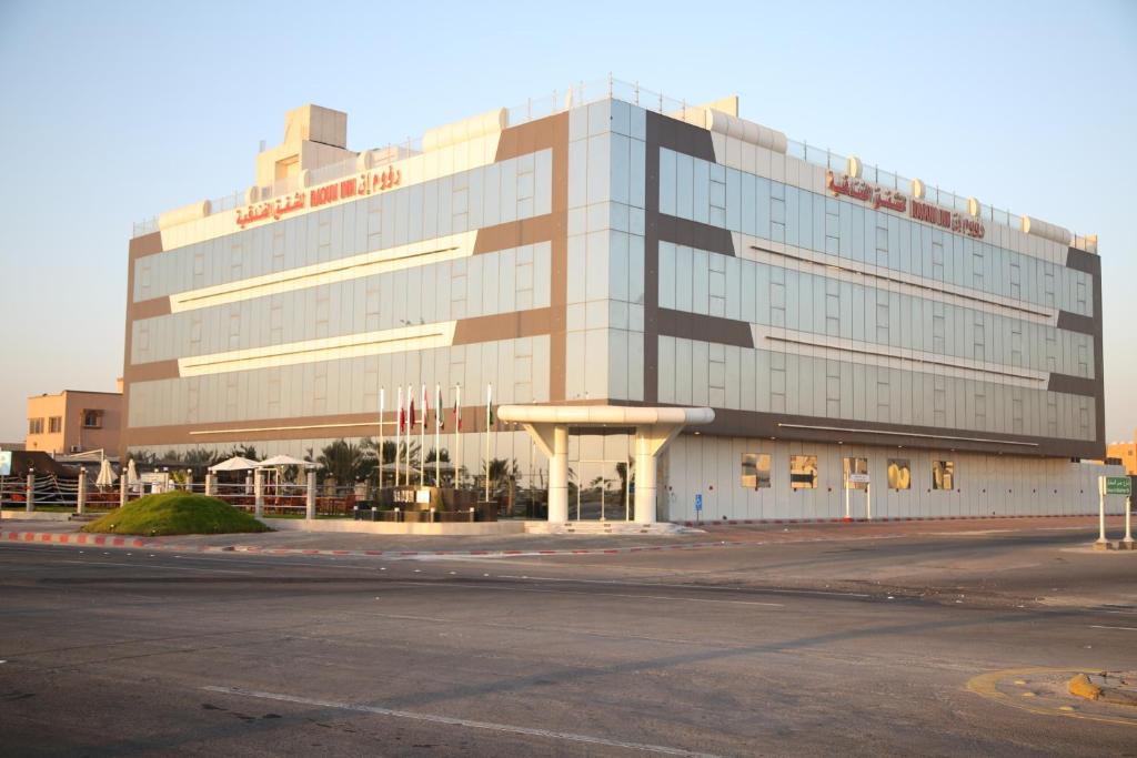 a large building in front of a parking lot at Raoum Inn Khafji Corniche in Khafji