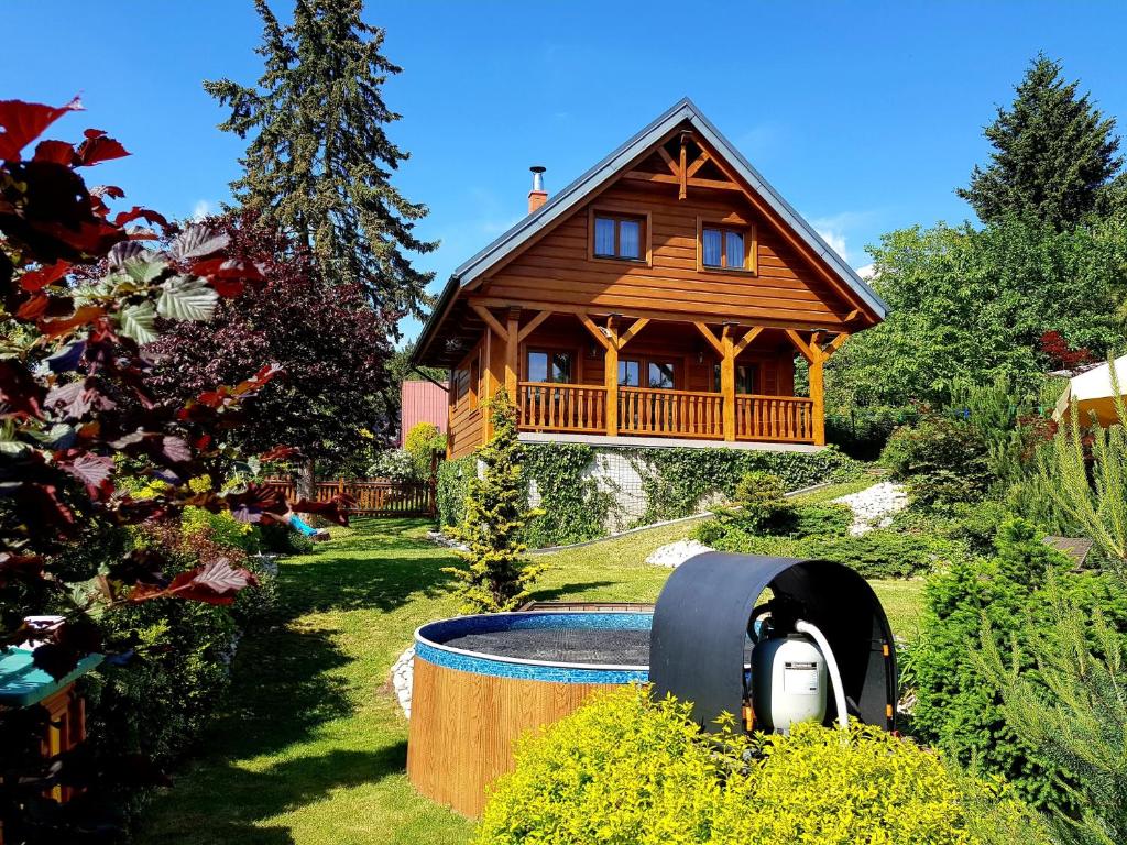 a wooden house with a hot tub in the yard at Chalupa u Macochy in Blansko