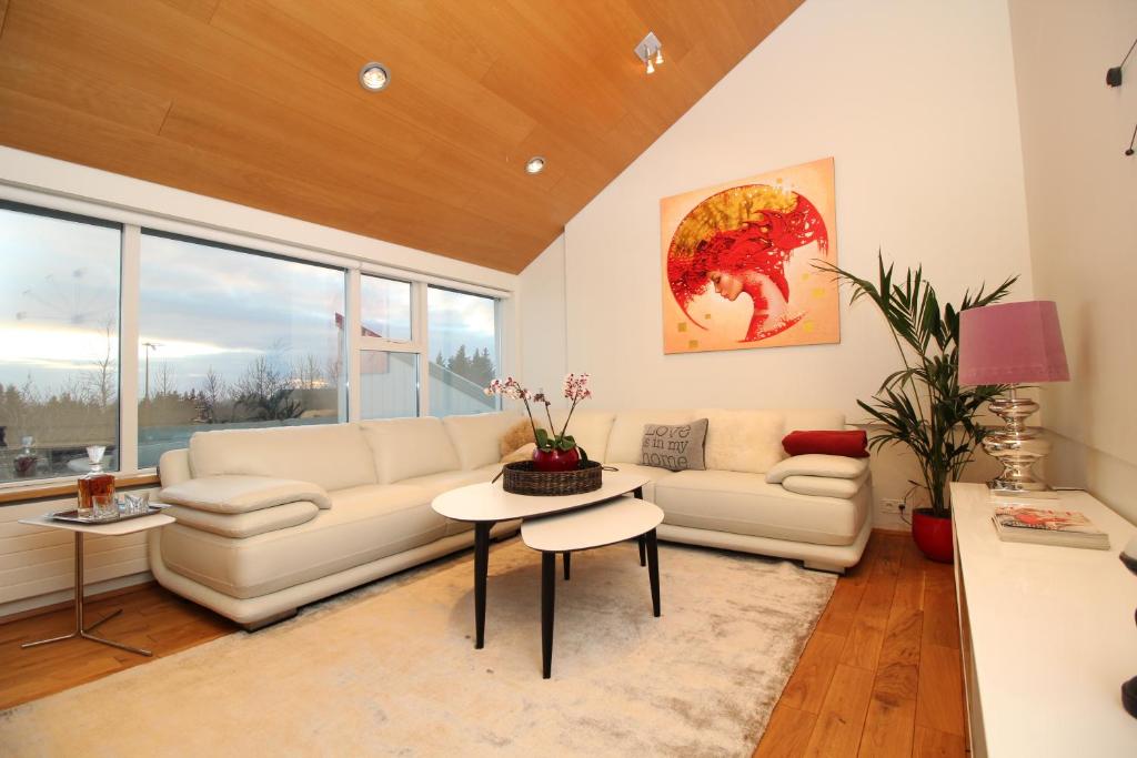 ein Wohnzimmer mit einem Sofa und einem Tisch in der Unterkunft Luxury Villa Reykjavík in Reykjavík