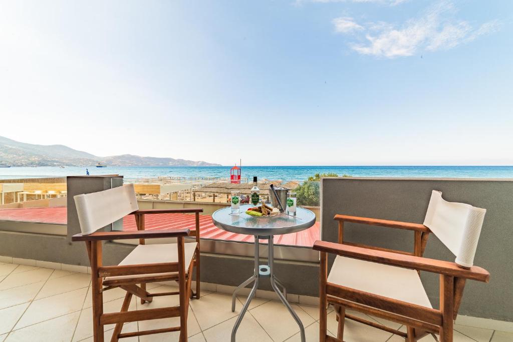 einen Balkon mit Tisch und Stühlen sowie Strand in der Unterkunft Tropical Beach B in Ammoudara