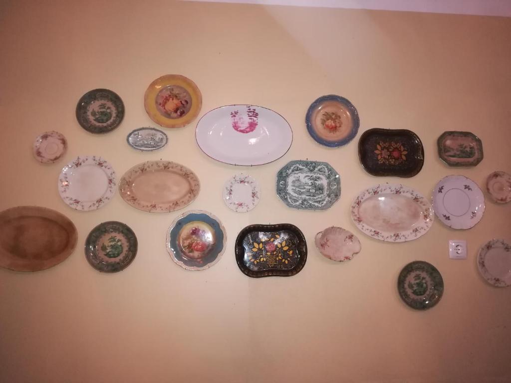 a bunch of plates hanging on a wall at D. TERESINHA in Vila de Frades