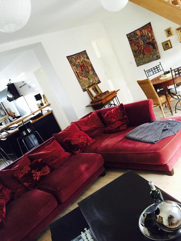 un salon avec un canapé rouge et une table dans l'établissement La Romanée, à Sallaumines