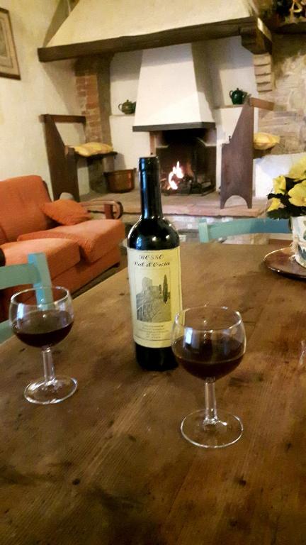 butelkę wina i dwa kieliszki na stole w obiekcie Casa Costanza w mieście Castiglione dʼOrcia