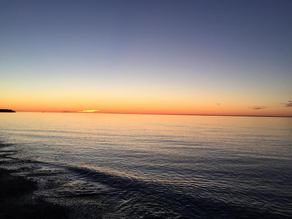 a sunset over a body of water with the horizon at gite des iles in Matane