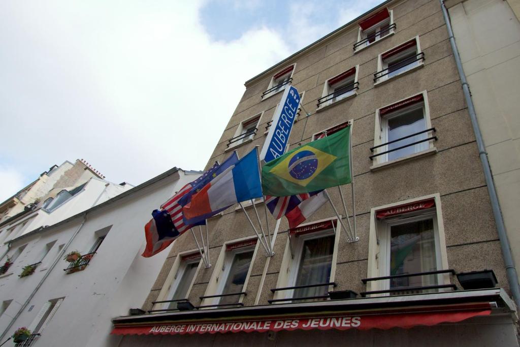 duas bandeiras na lateral de um edifício em Auberge Internationale des Jeunes em Paris