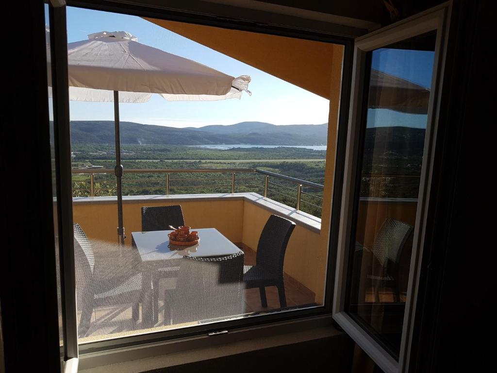 a balcony with a table and an umbrella at Apartment Panorama in Kotor