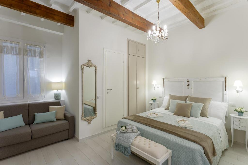 a white bedroom with a large bed and a couch at Accademia Gallery Charming Suite in Florence