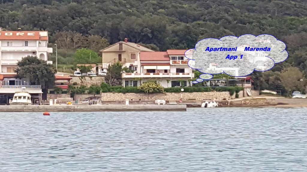 a cloud over a body of water next to houses at Apartmani Marenda in Supetarska Draga