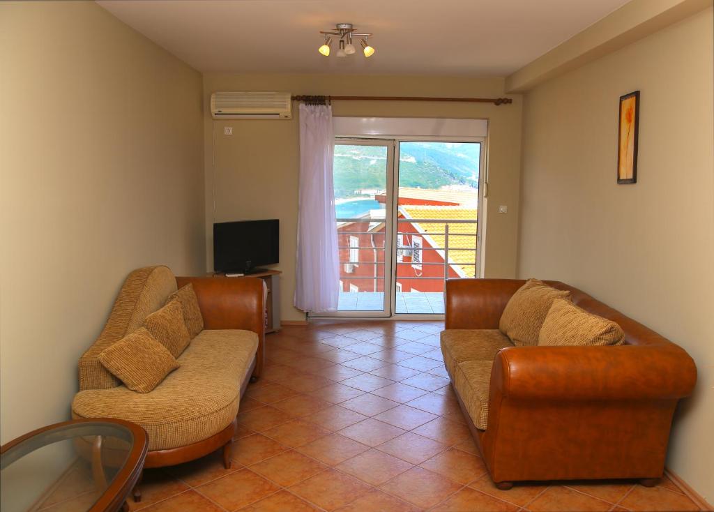 a living room with two chairs and a couch and a television at Ana in Budva