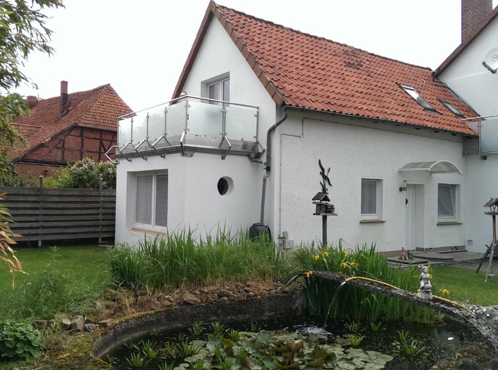 Cette maison blanche dispose d'un balcon. dans l'établissement Anbau, à Evestorf