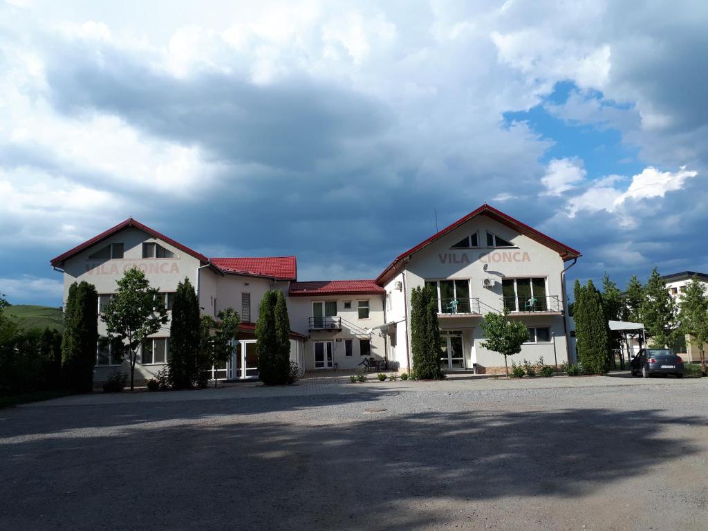 un grand bâtiment blanc avec des toits rouges dans l'établissement Pensiunea Cionca str 1 Decembrie 1918 nr 466, à Gilău