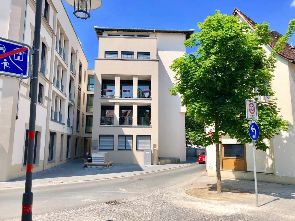 an empty street with a building and a tree at brauHAUS in Forchheim