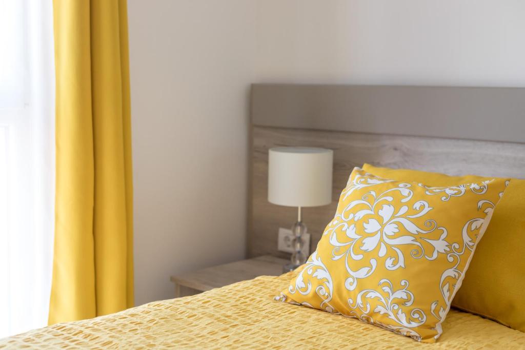 a yellow pillow sitting on a bed next to a window at Luxury room & studio Stella Maris in Split