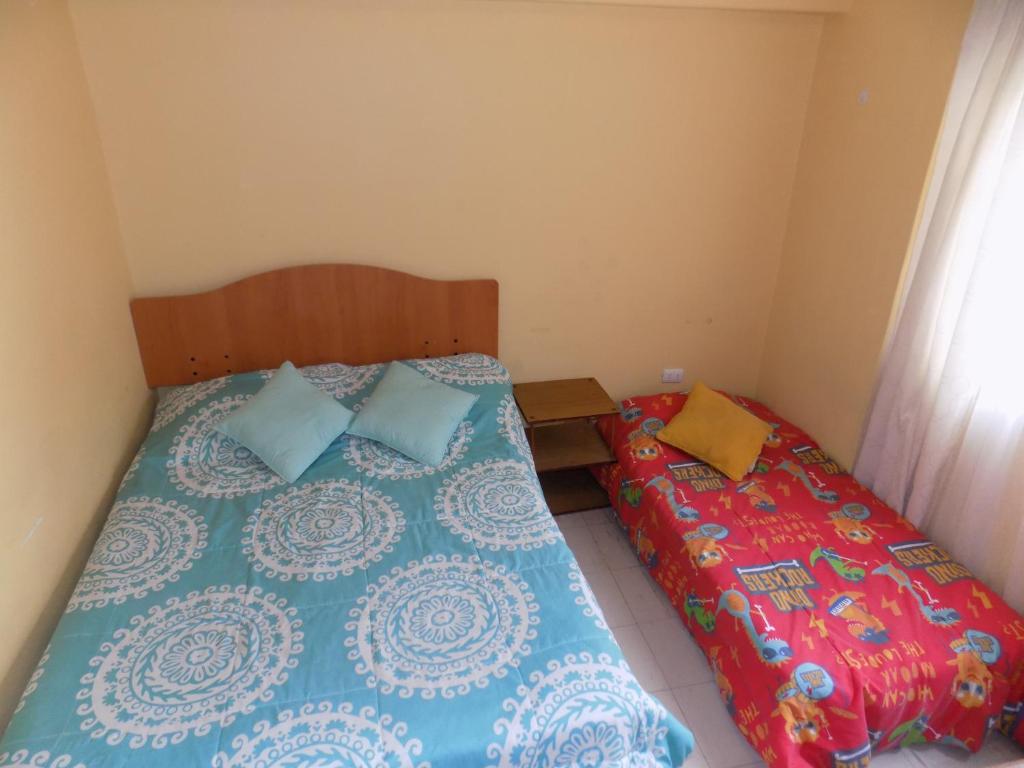 Duas camas num pequeno quarto com colchões em Alojamiento económico a pasos del Jumbo! em La Serena