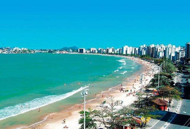 una playa con gente y el océano y una ciudad en Victory Business Flat, en João Pessoa