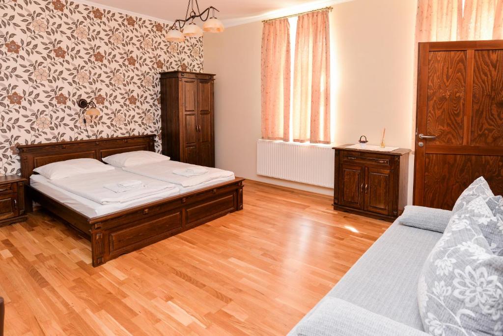 1 dormitorio con 1 cama y suelo de madera en Althaus Vendégház, en Németkér