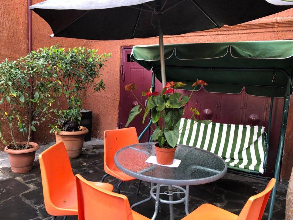 a table and chairs with an umbrella on a patio at The house of the botanist in Tbilisi City