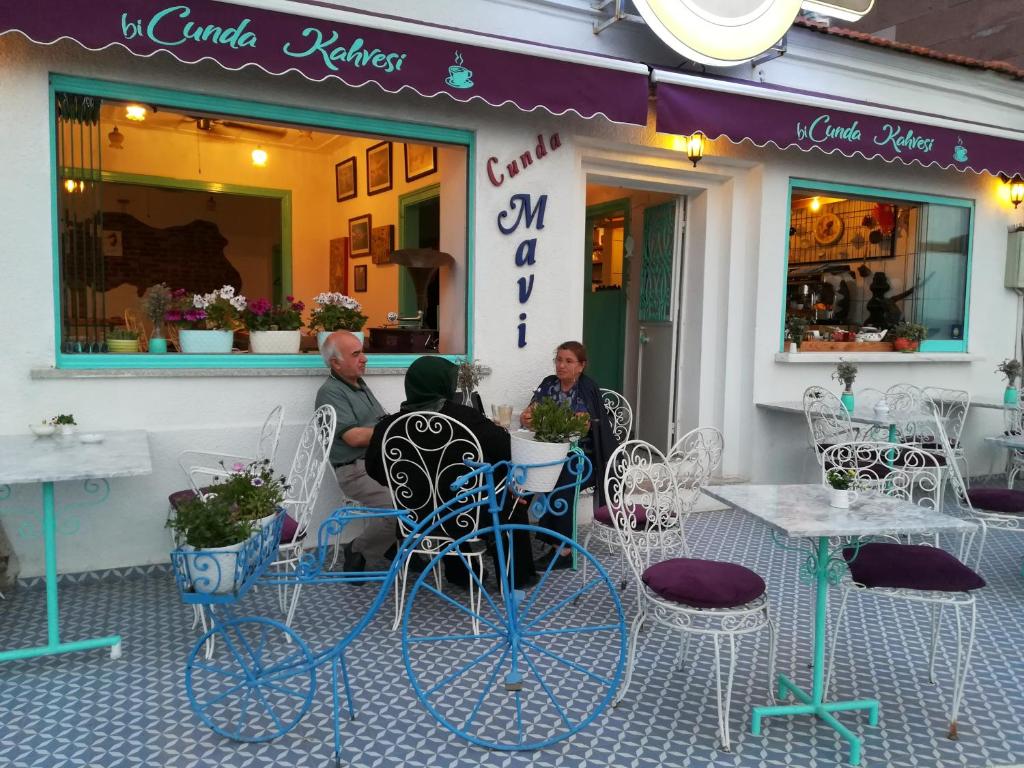 a group of people sitting outside of a restaurant at Cunda Mavi Hotel in Ayvalık