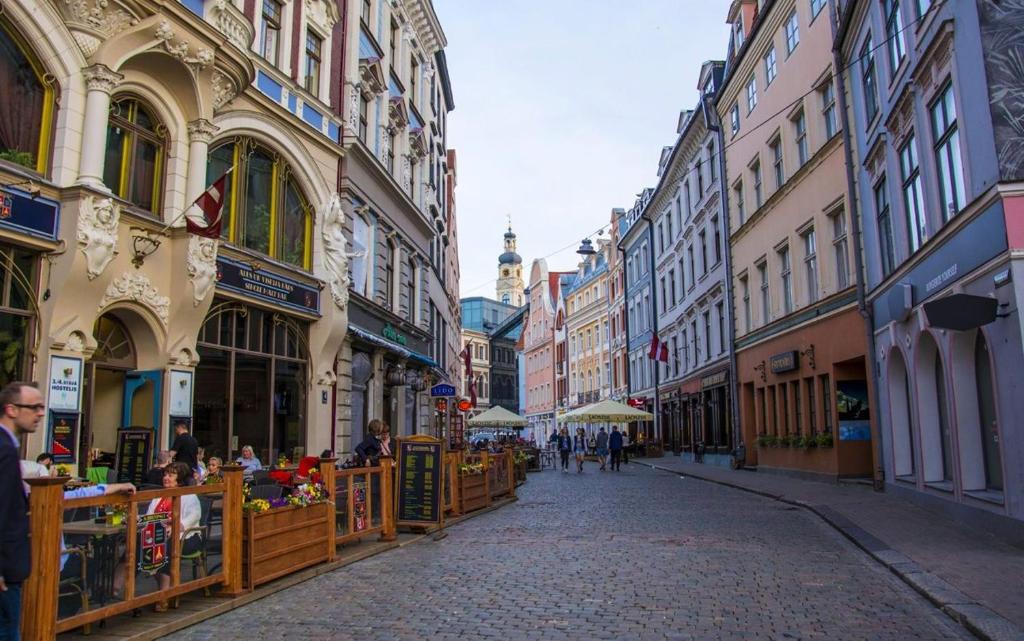 una calle de la ciudad con edificios y gente caminando por una calle en Old City Residence Riharda Vagnera en Riga