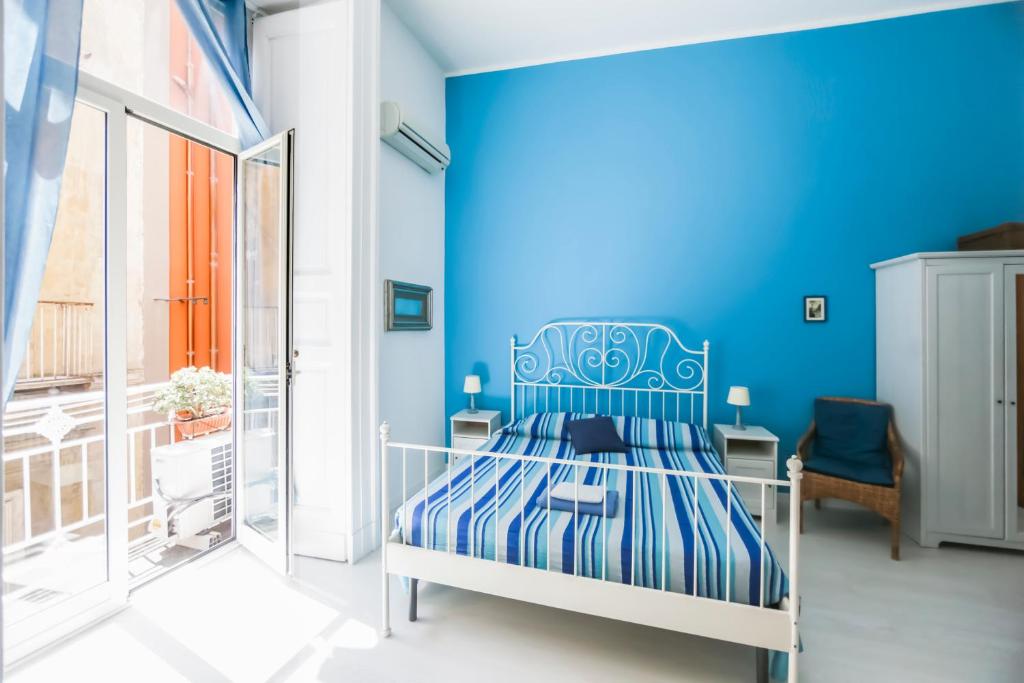 a blue bedroom with a bed with a blue wall at Camera Con Vista Apartments in Naples