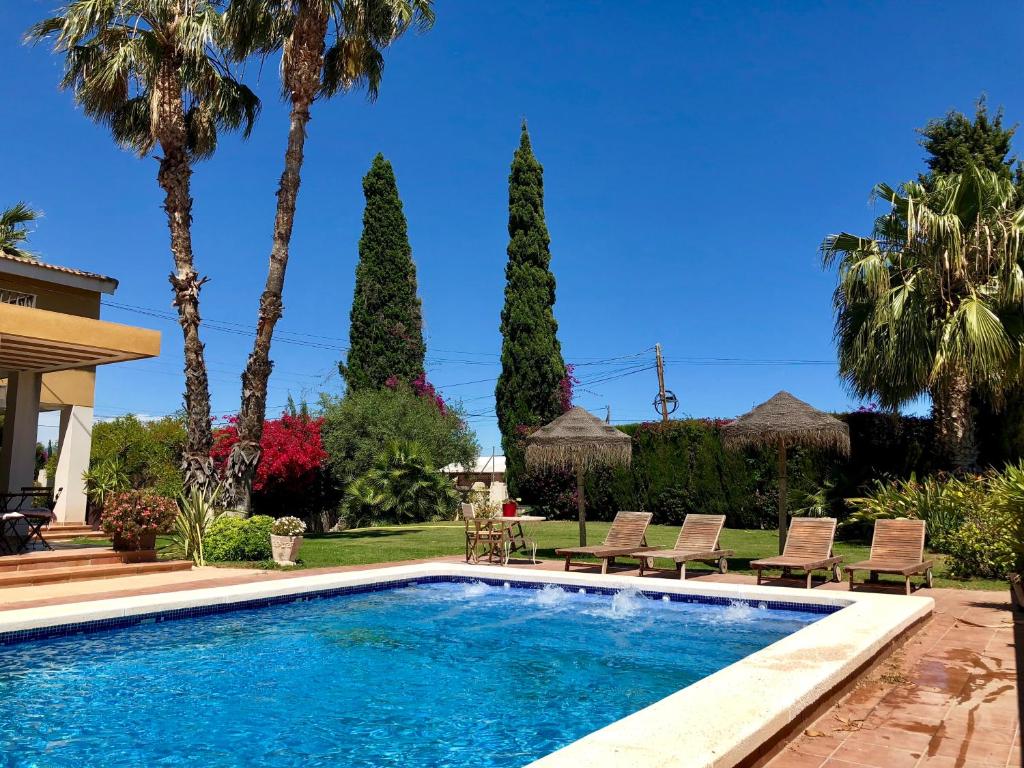 a swimming pool in a yard with palm trees at ***CHALET ALICANTE*** EXPERIENCIA UNICA in Alicante