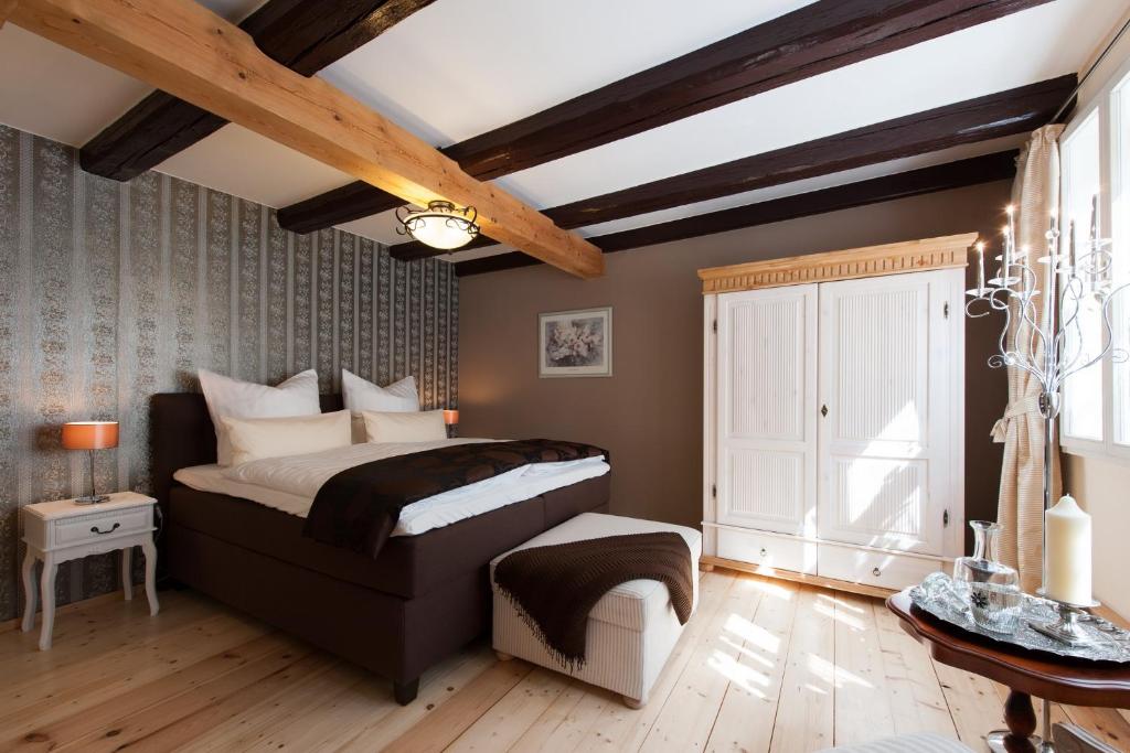 クヴェードリンブルクにあるFerienhaus Schlossgartenの木製の天井が特徴のベッドルーム1室(大型ベッド1台付)
