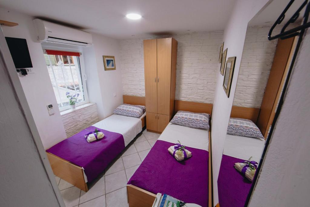 Cette chambre comprend 2 lits avec des coussins violets. dans l'établissement Old Town Apartment Split, à Split